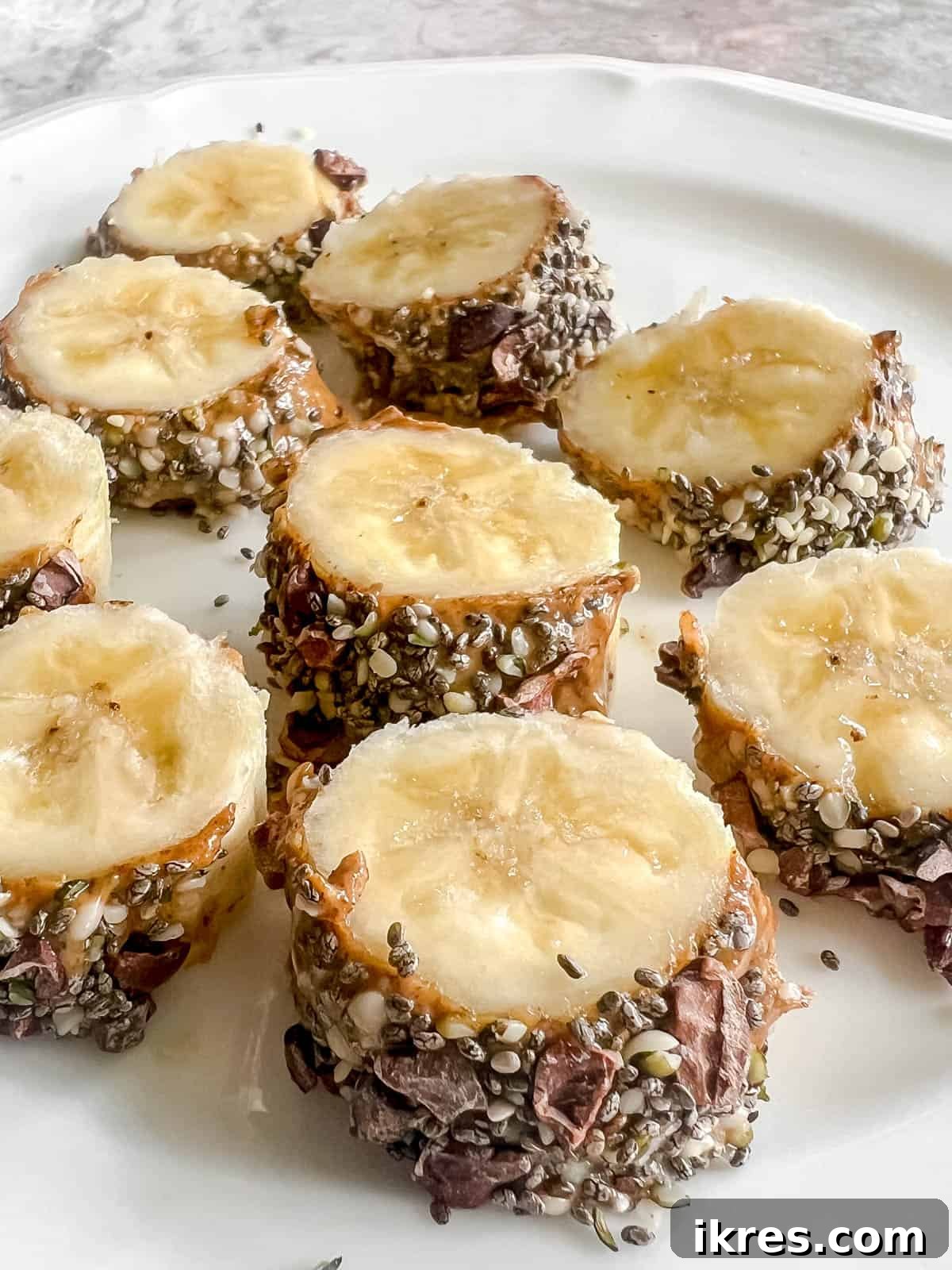 Banana Breakfast Pinwheels 2 Vibrantly arranged banana breakfast sushi slices on a rustic plate, topped with various healthy seeds and nuts.