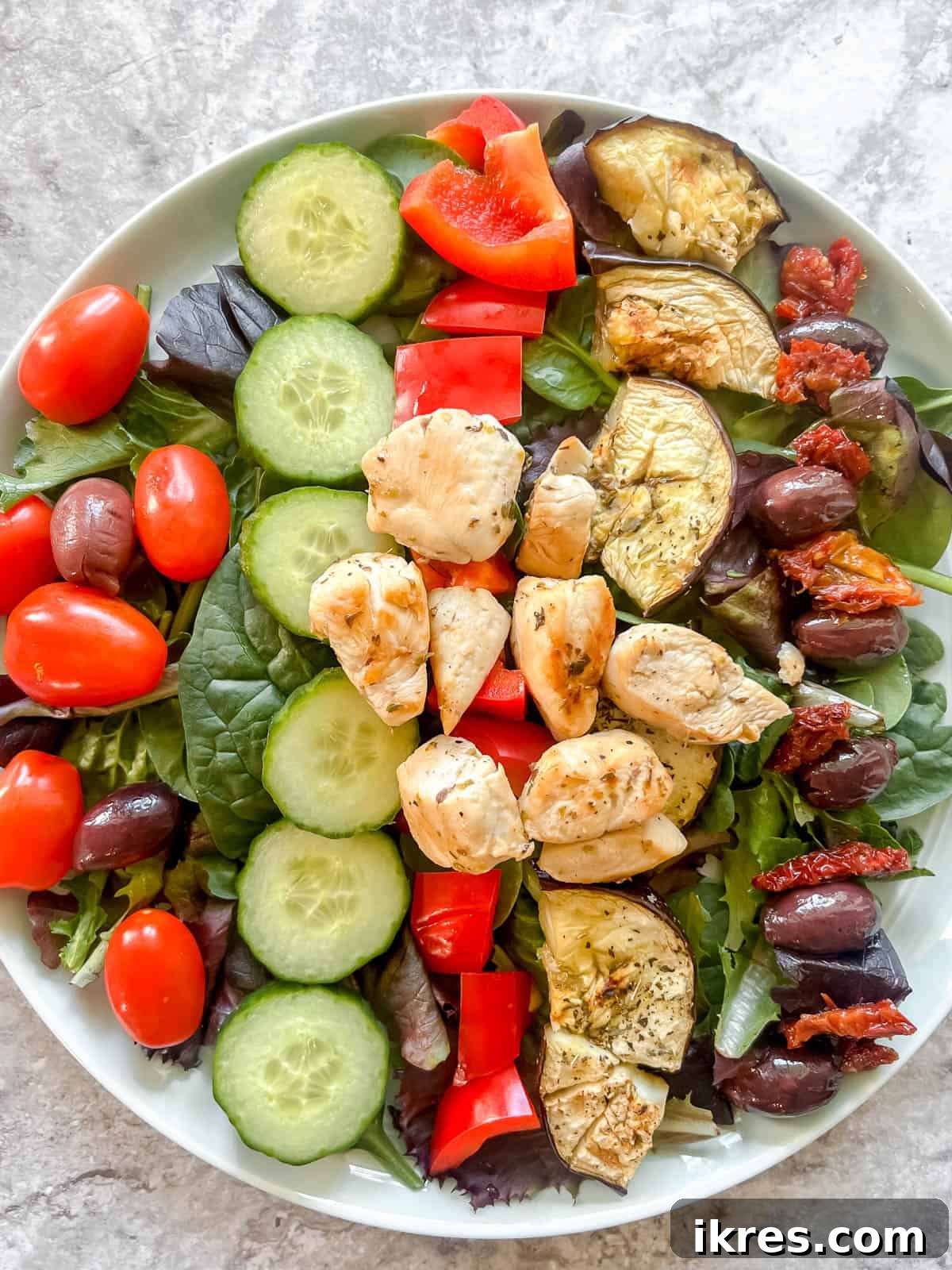 Vibrant Grilled Chicken Greek Salad 14 Succulent grilled chicken pieces being added to complete the hearty Greek salad.