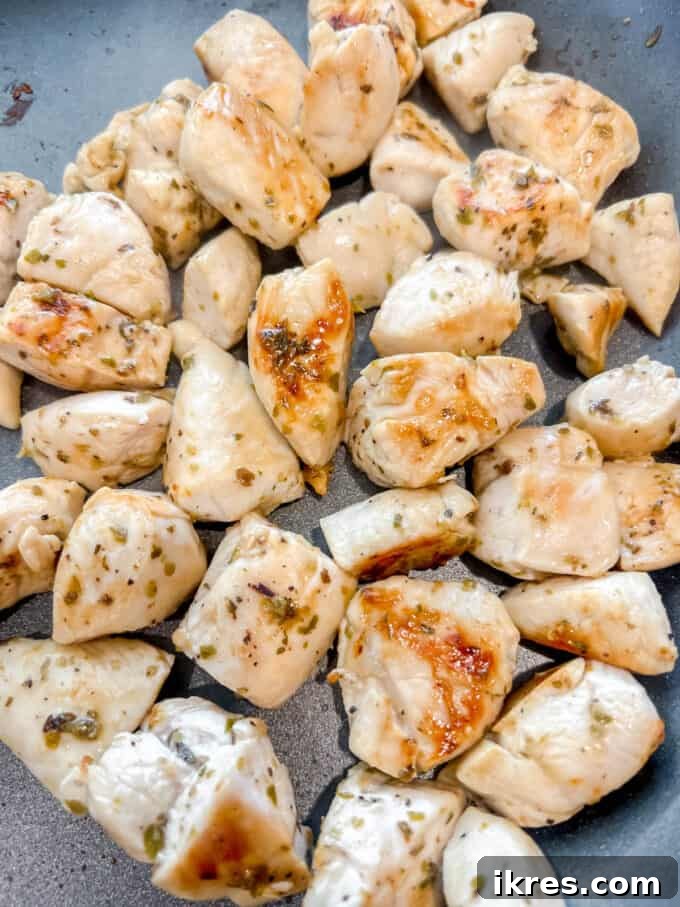Vibrant Grilled Chicken Greek Salad 6 Lemon oregano chicken pieces grilling in a hot pan until perfectly golden brown and fully cooked.