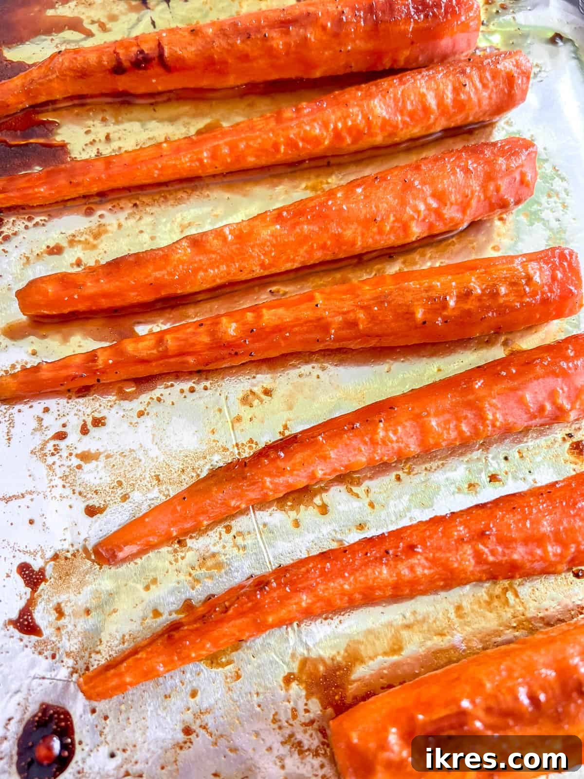 Sunshine Maple Glazed Carrots 2 Freshly roasted turmeric maple glazed carrots, glistening with glaze, just out of the oven.