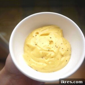 Homemade Paleo mayonnaise in a small glass dish, ready to be served. A healthy and delicious gluten-free condiment.