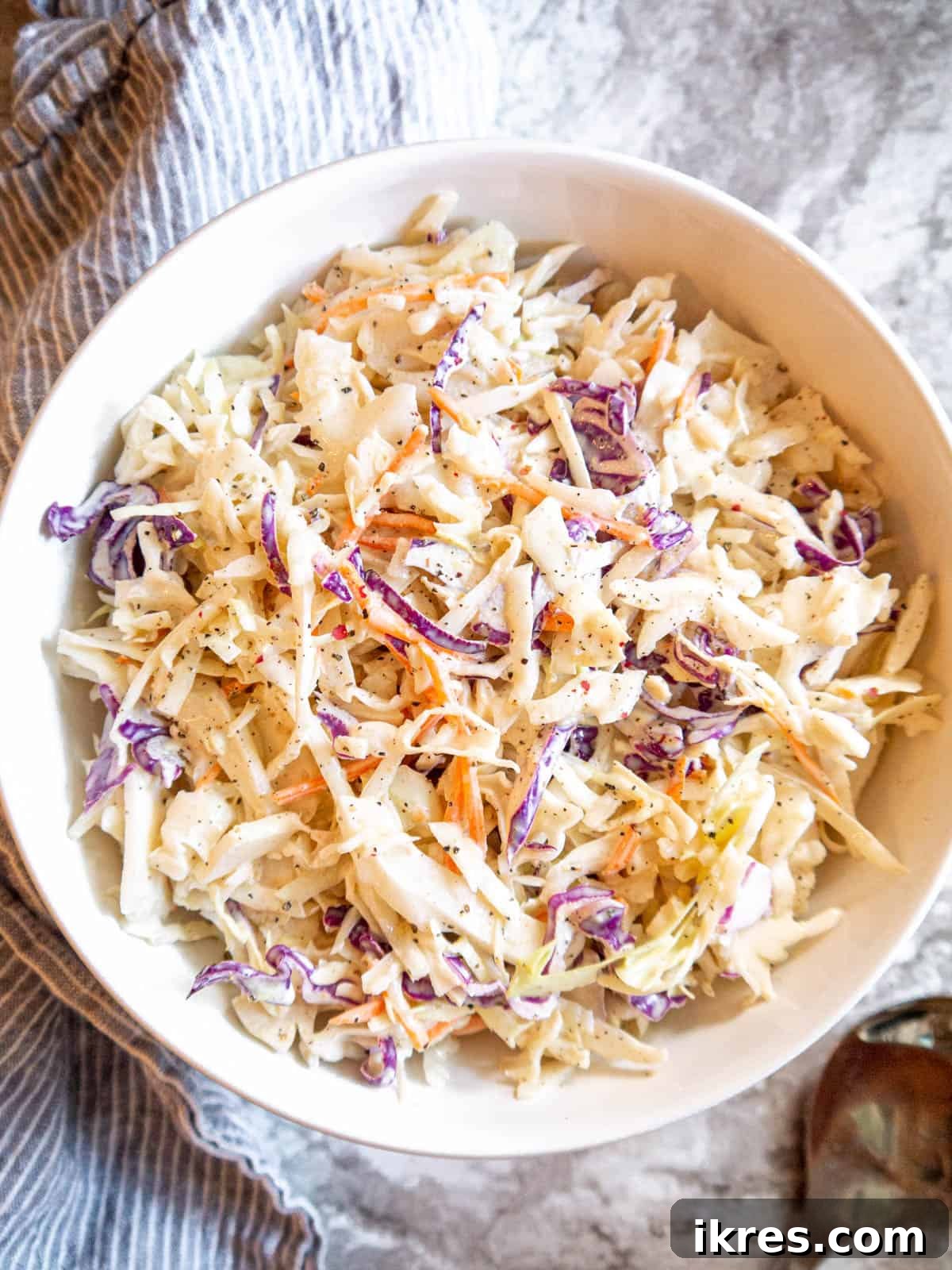 A large bowl of creamy Paleo coleslaw ready to be scooped and enjoyed.