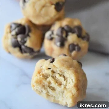No bake energy bites, one with a bite taken out of it, showcasing its tempting interior.