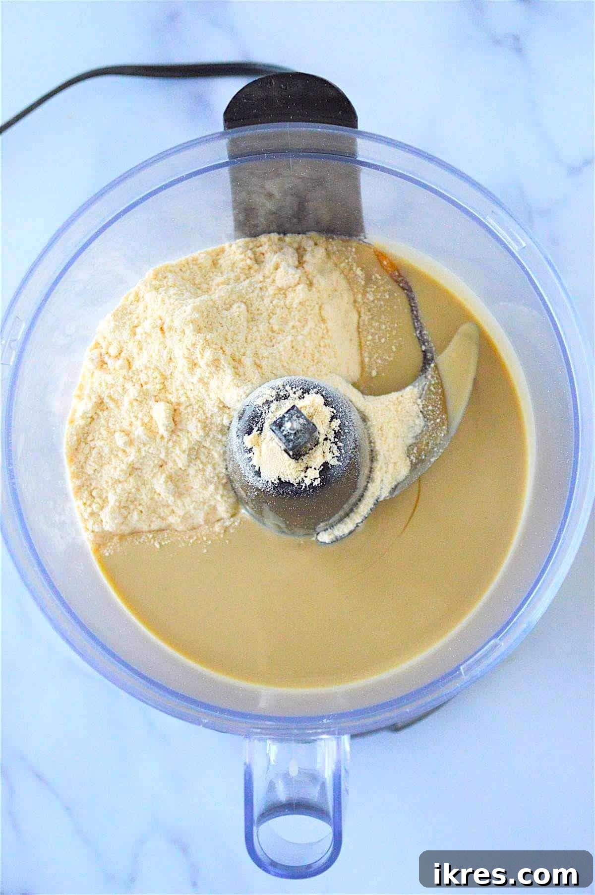 Easy No-Bake Power Bites 5 Tahini, honey, and coconut flour being combined in a food processor, capturing the initial mixing stage of no-bake energy balls.