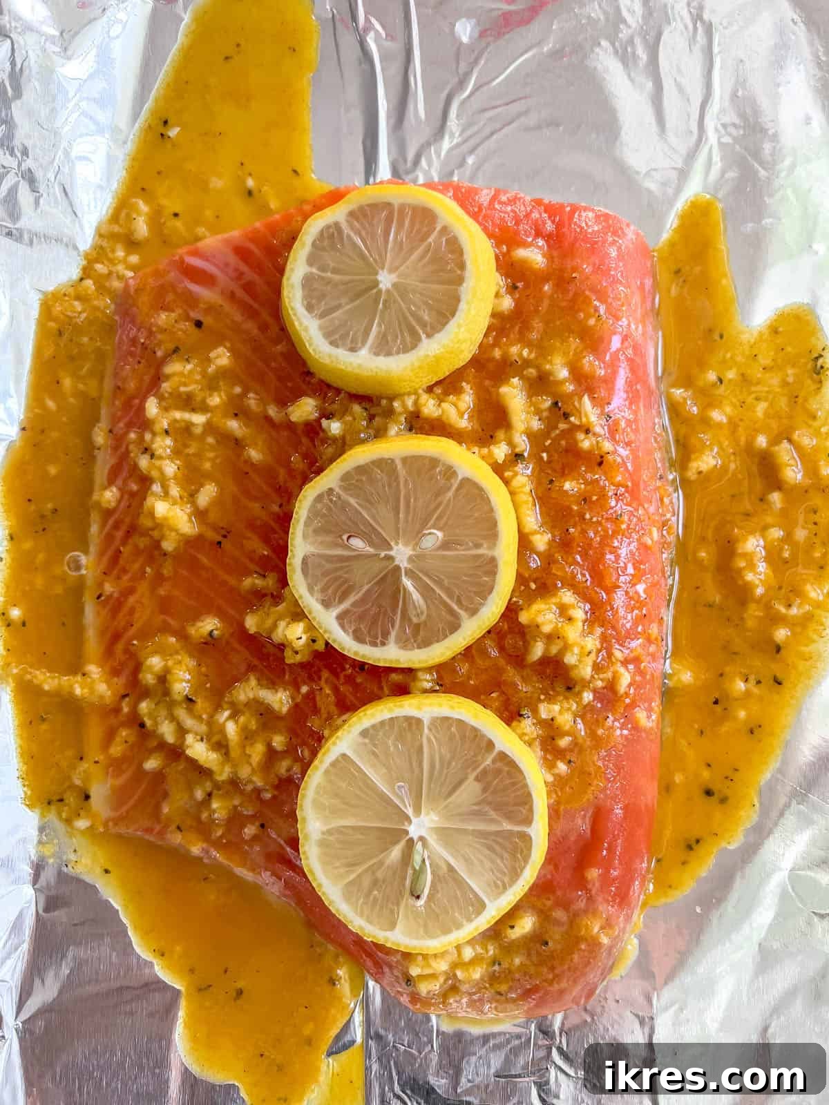 Lemon slices arranged on top of the salmon fillet, covered in sauce.
