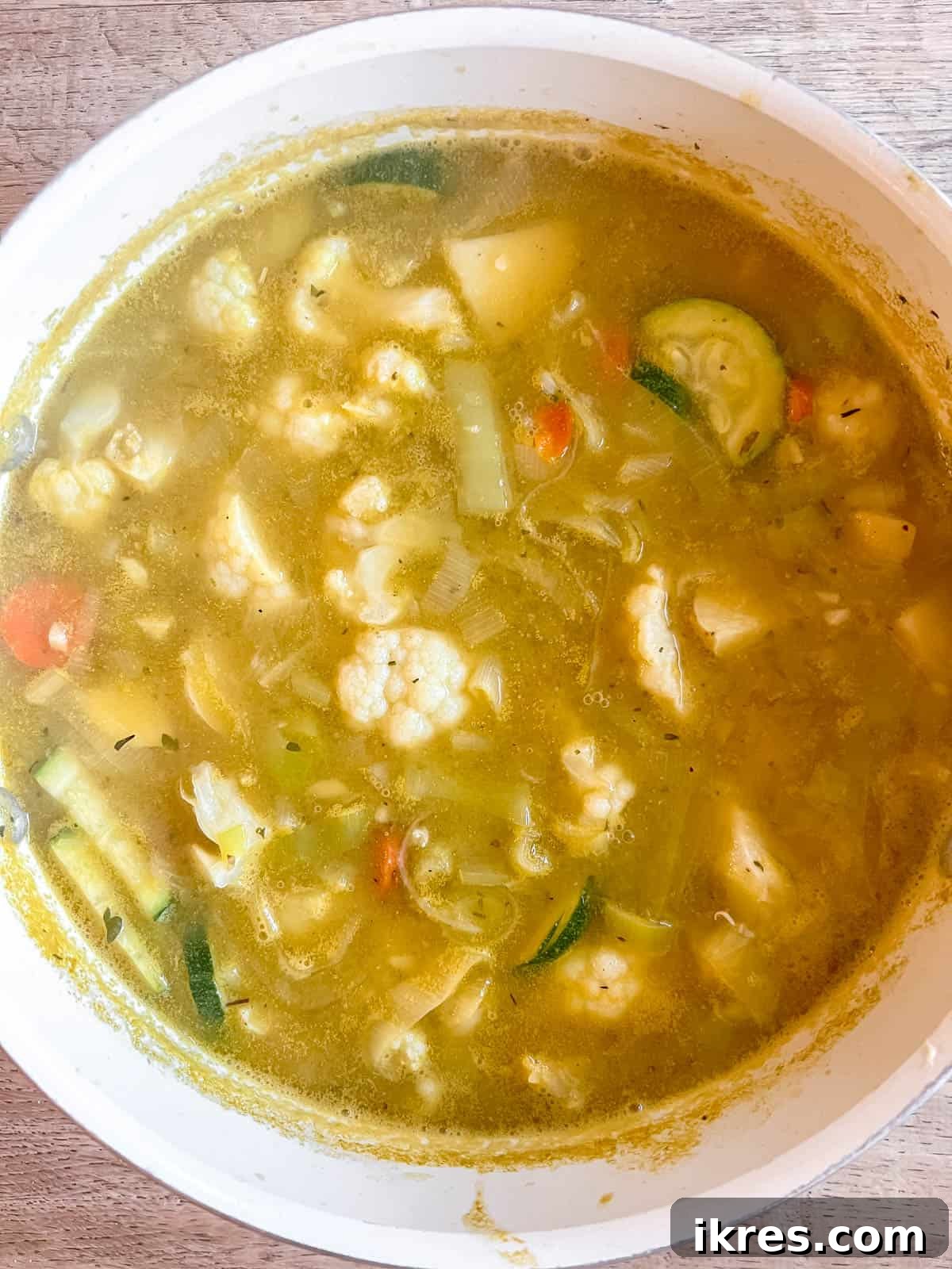 Sliced zucchini added to the simmering chicken and leek soup.