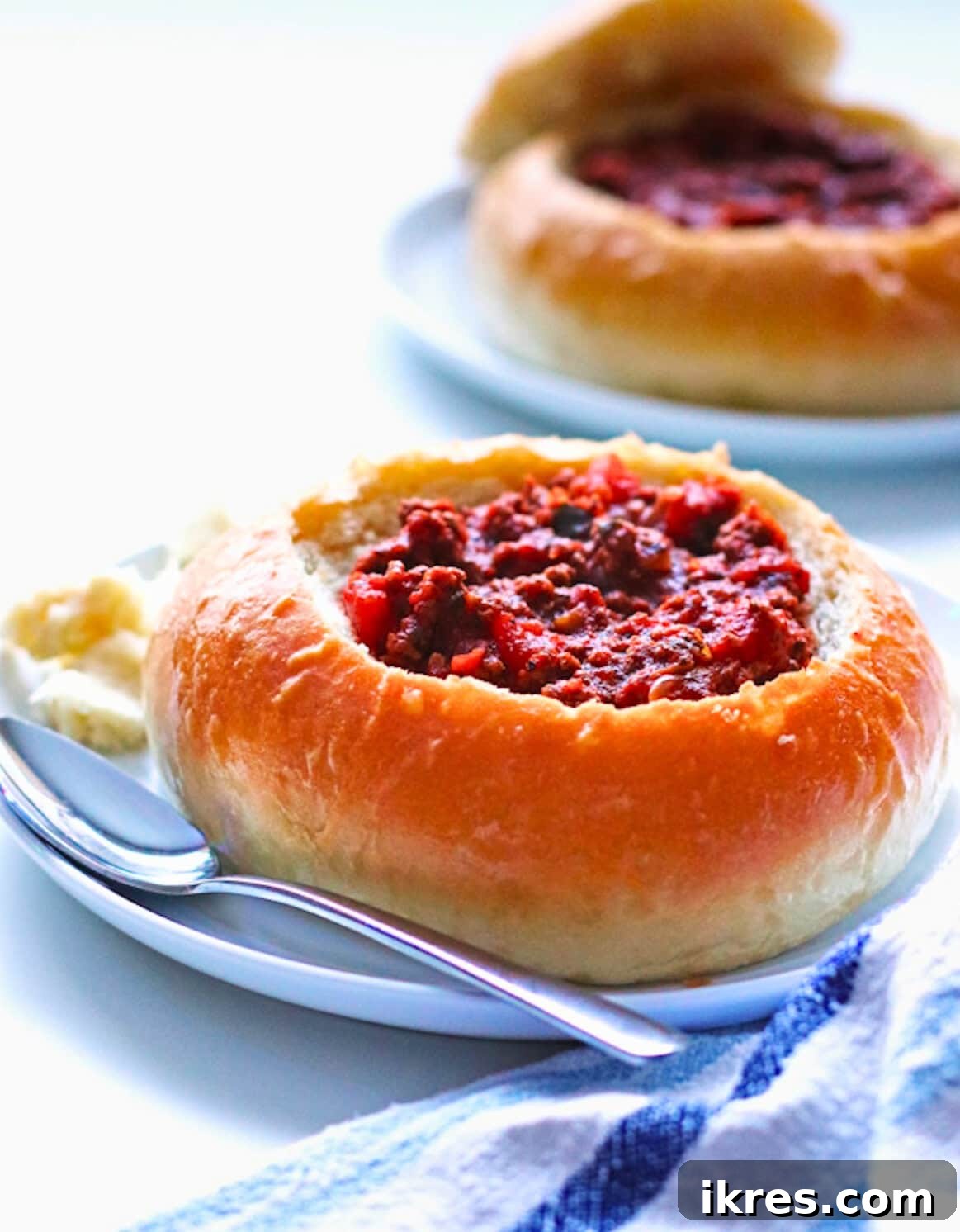 Effortless Homemade Chili 2 A steaming bowl of Quick and Easy Chili, served in a homemade bread bowl, garnished with a sprinkle of shredded mozzarella cheese.