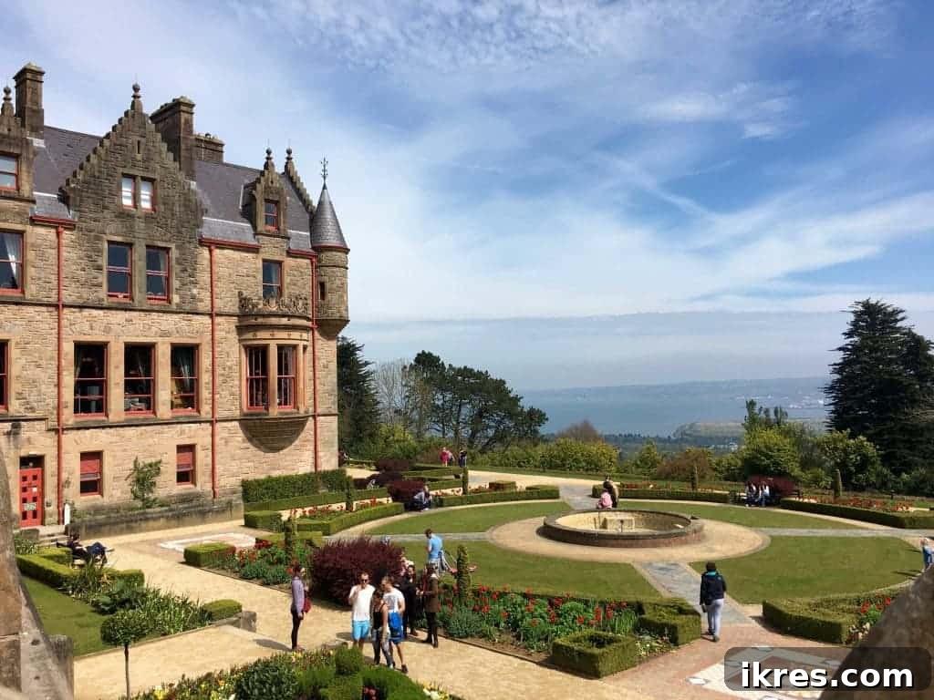 The majestic Belfast Castle overlooking the city and the sea, set against a lush green backdrop.