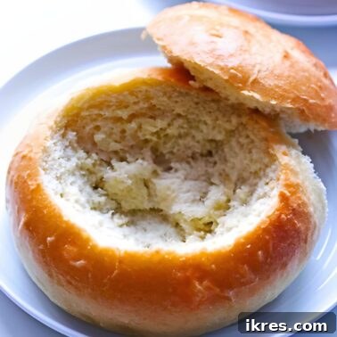 A hollowed out bread bowl on a white plate.