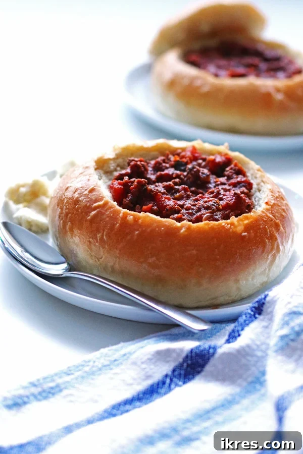 A stack of golden brown bread bowls on a cooling rack.