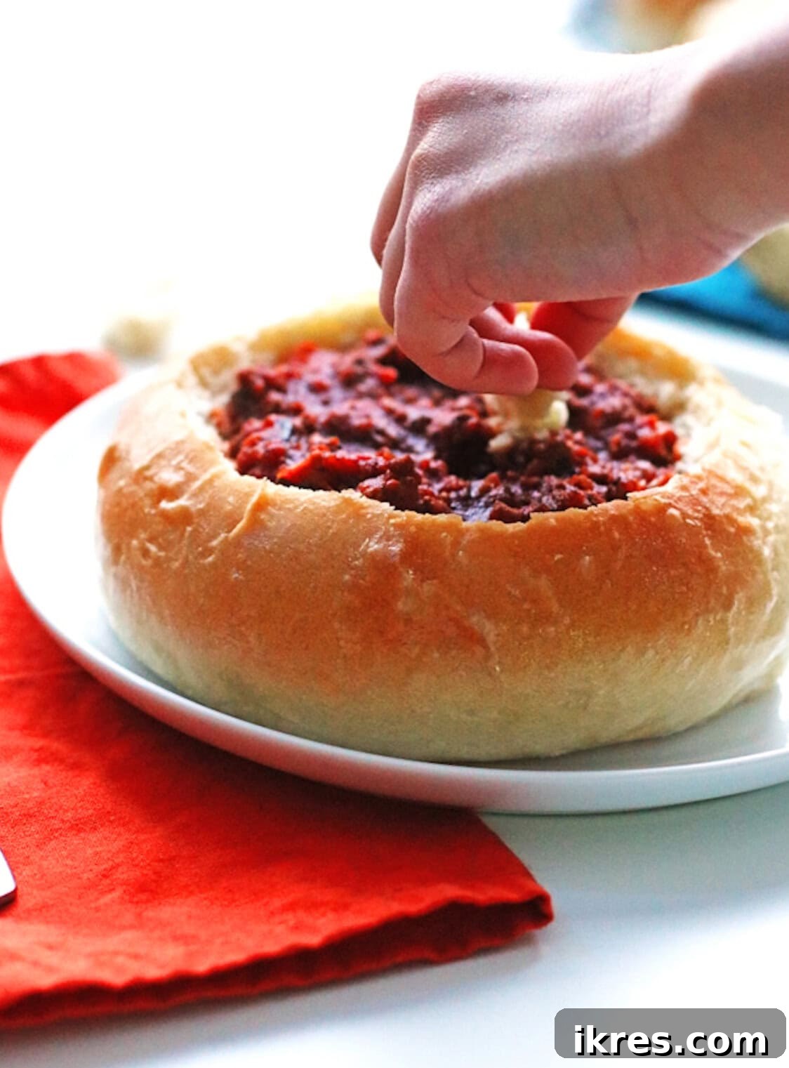 Overhead view of homemade bread bowls filled with chili, garnished with cheese and sour cream.
