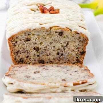 Buttermilk Banana Bread Perfection 12 A cross section of a loaf of buttermilk banana bread with cream cheese frosting drizzled on the top.