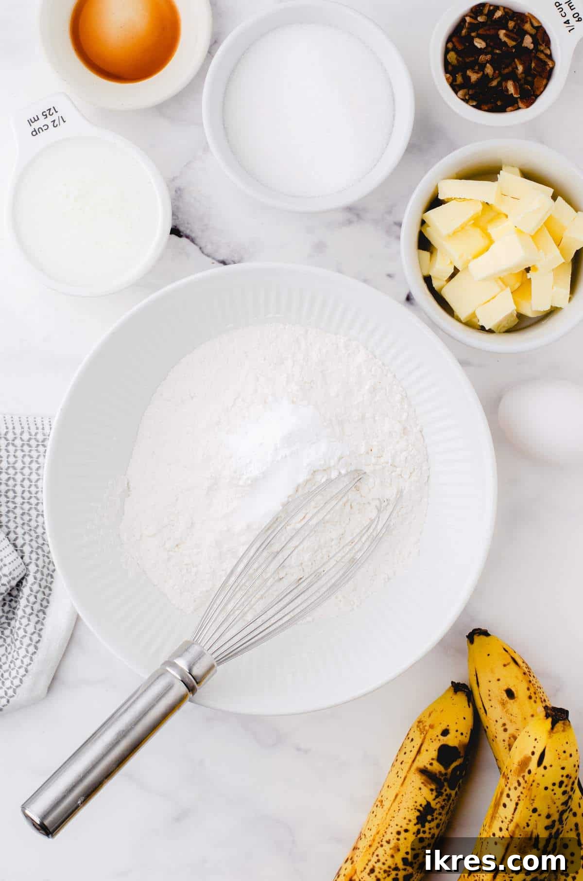 Buttermilk Banana Bread Perfection 4 A white bowl holds the meticulously combined dry ingredients for buttermilk banana bread, ready for the next step.