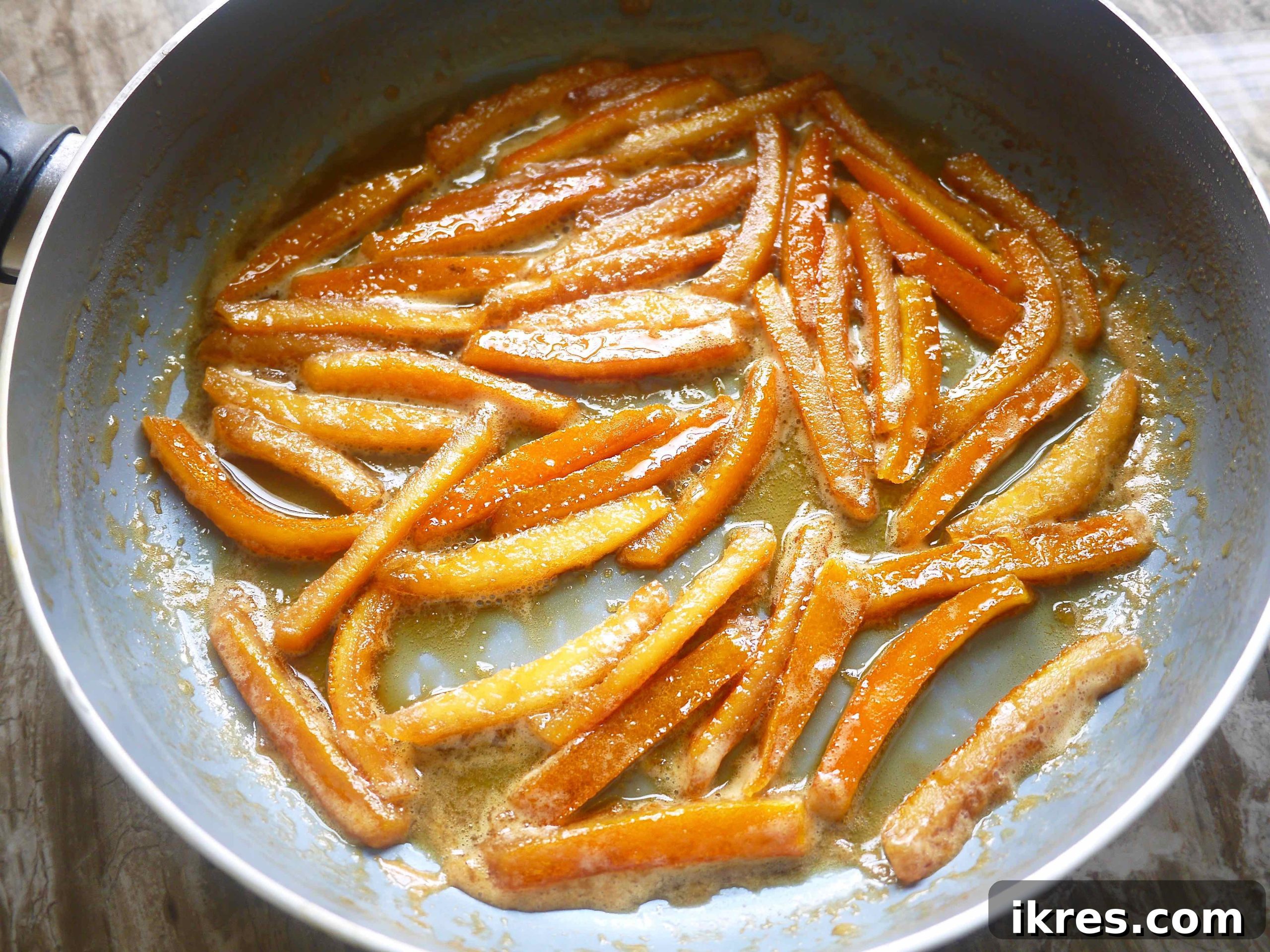 Paleo Honey Candied Orange Peels 7 Orange peels in a pan covered in honey and water.