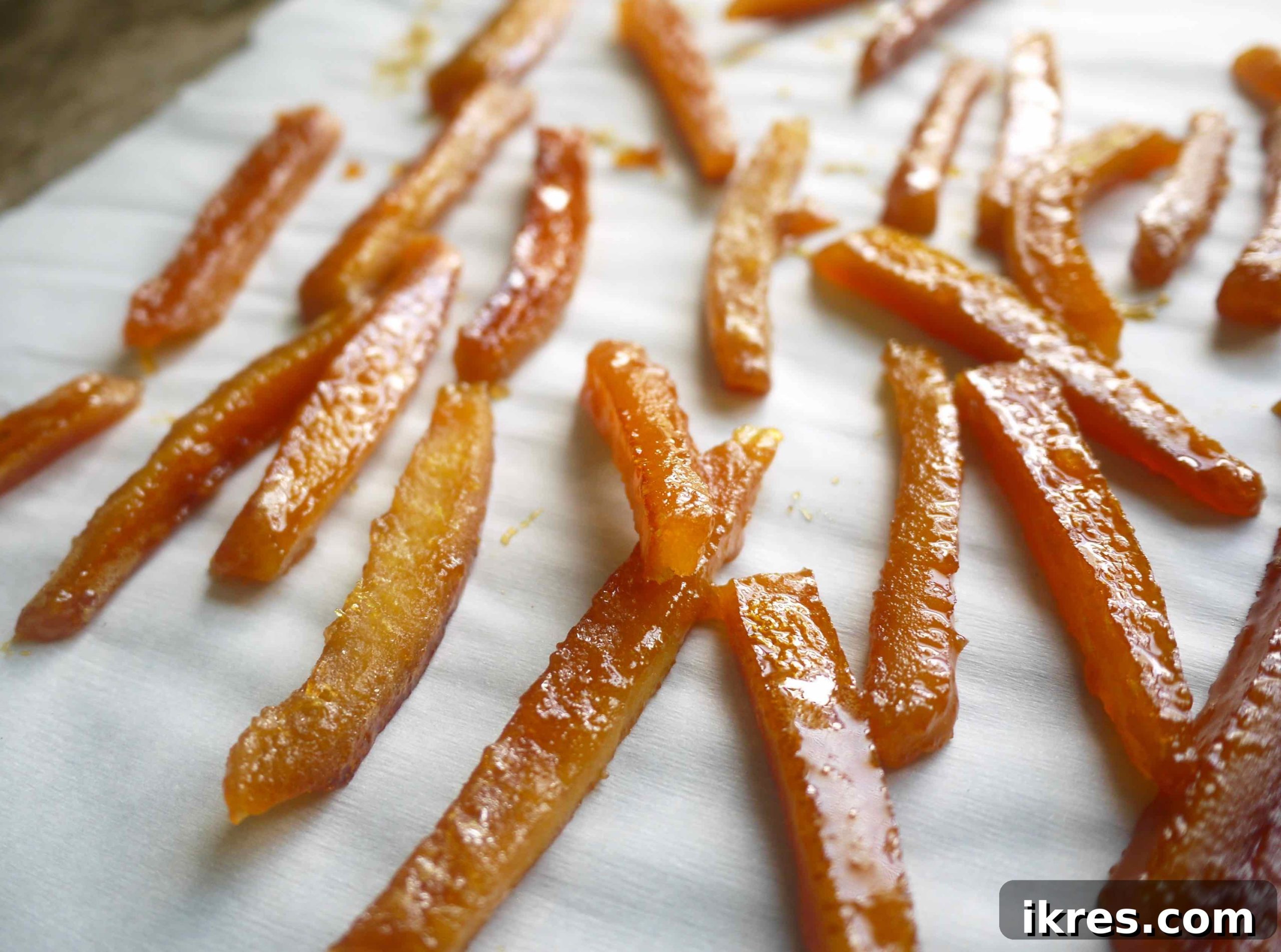 Paleo Honey Candied Orange Peels 8 Freshly candied orange peels drying on parchment paper.