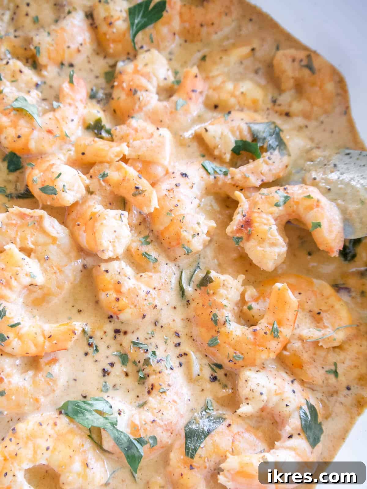 Ağızda Dağılan Paleo Paprika Sarımsaklı Karides 7 Creamy dairy-free shrimp prepared in a coconut cream sauce within a large, glistening skillet.