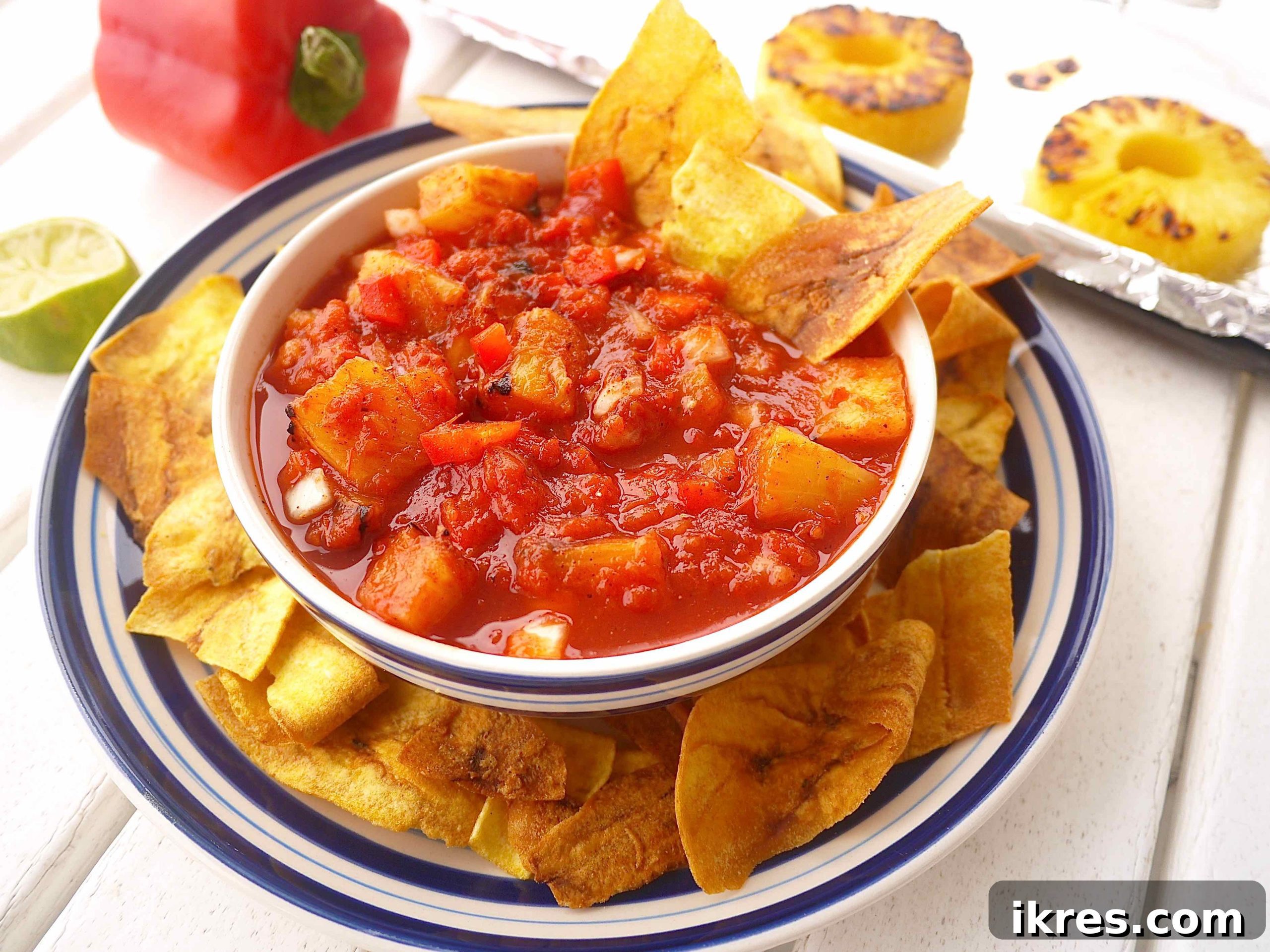 Sunshine & Smoke Salsa 5 All the vibrant, fresh ingredients for the roasted pineapple salsa, including finely chopped tomatoes, red bell pepper, and white onion, mixed in a large glass bowl.