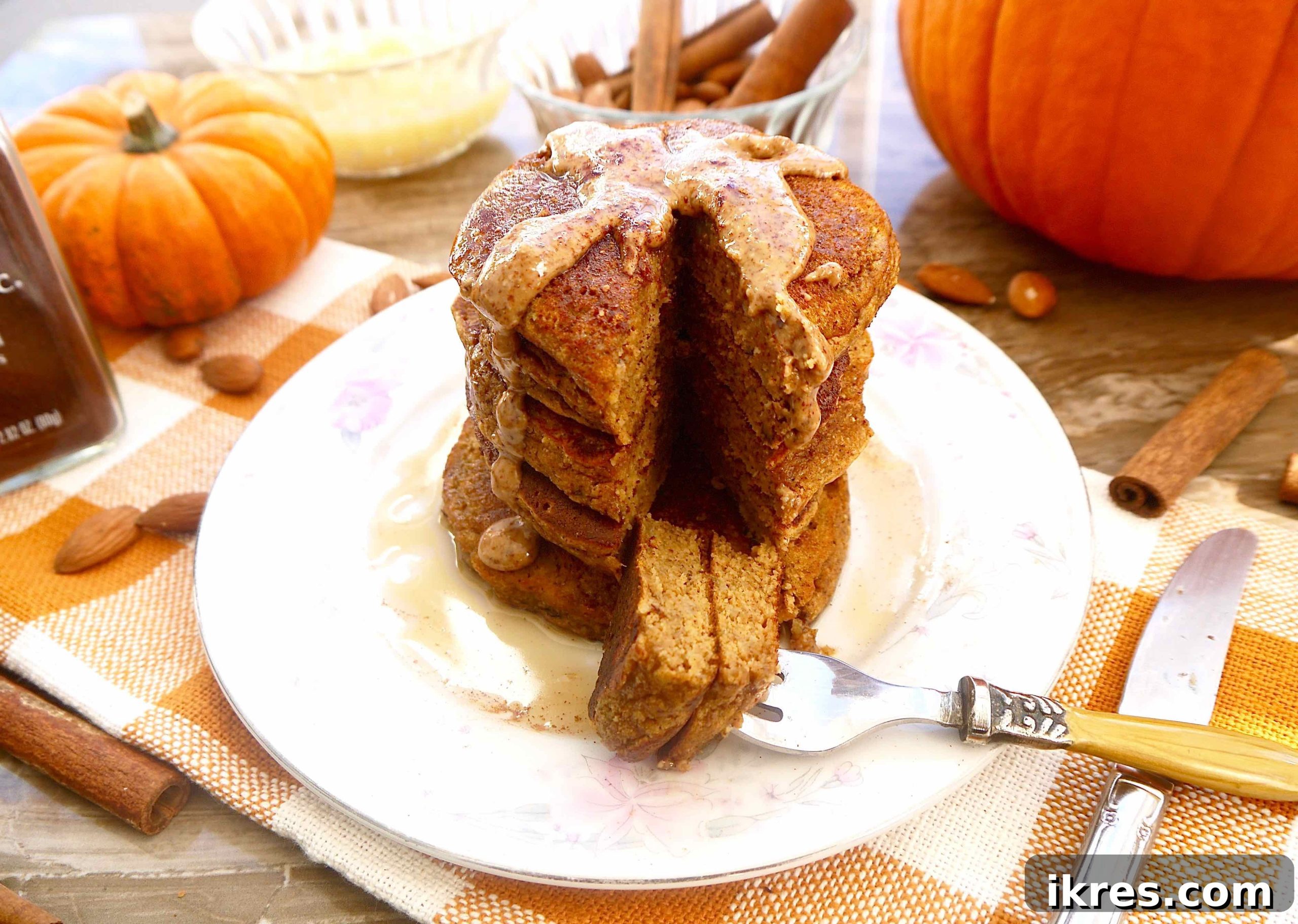 A perfectly cooked, grain-free pumpkin pancake with a bite taken out, showing its fluffy interior.