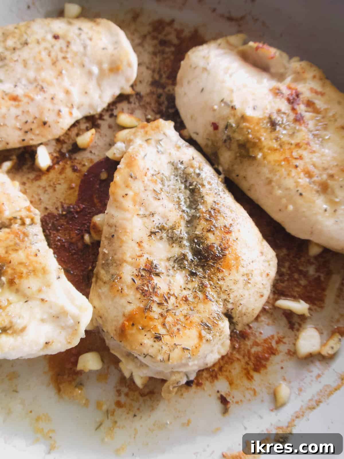 Grilled chicken pieces with sautéed shallots and garlic in a pot.