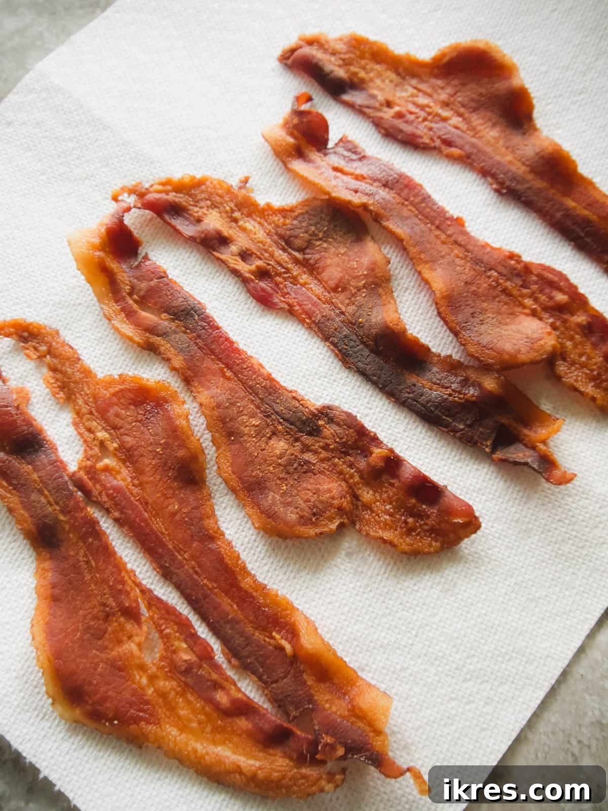 Crispy bacon strips freshly cooked on a plate.