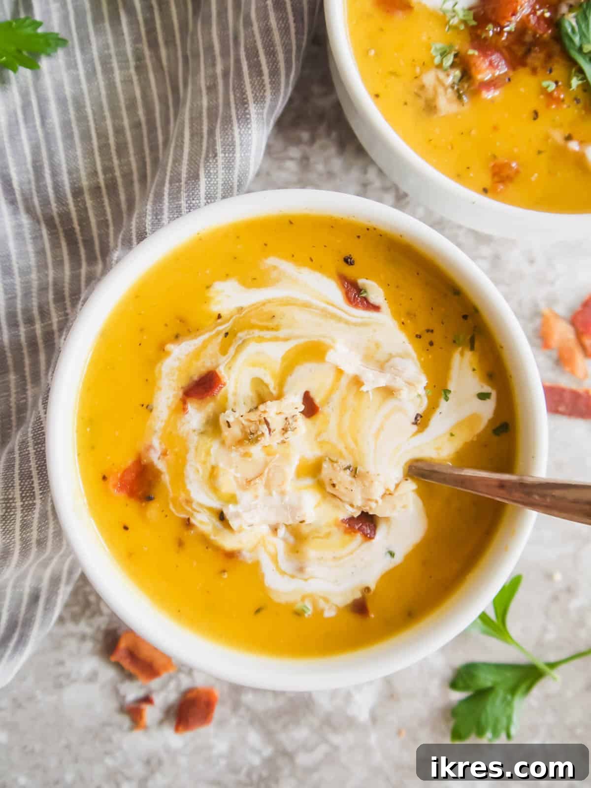 Butternut squash soup with bacon and chicken pieces in a bowl, ready to eat.