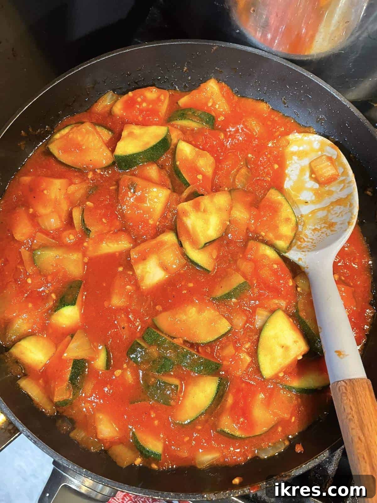 Perfect Oven-Roasted Italian Sausage 8 A frying pan with sautéed zucchini and tomato sauce in it.
