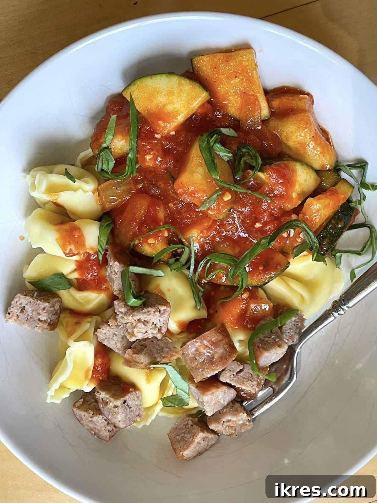 Perfect Oven-Roasted Italian Sausage 9 A bowl of cheese tortellini with oven cooked Italian sausahe, sauteed zucchini, homemade tomato sauce, & fresh basil.