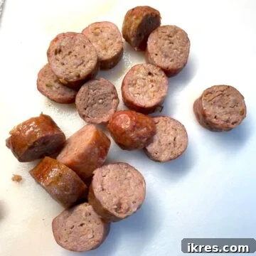 Perfect Oven-Roasted Italian Sausage 10 Oven-cooked, sliced Italian sausage on a white cutting board.
