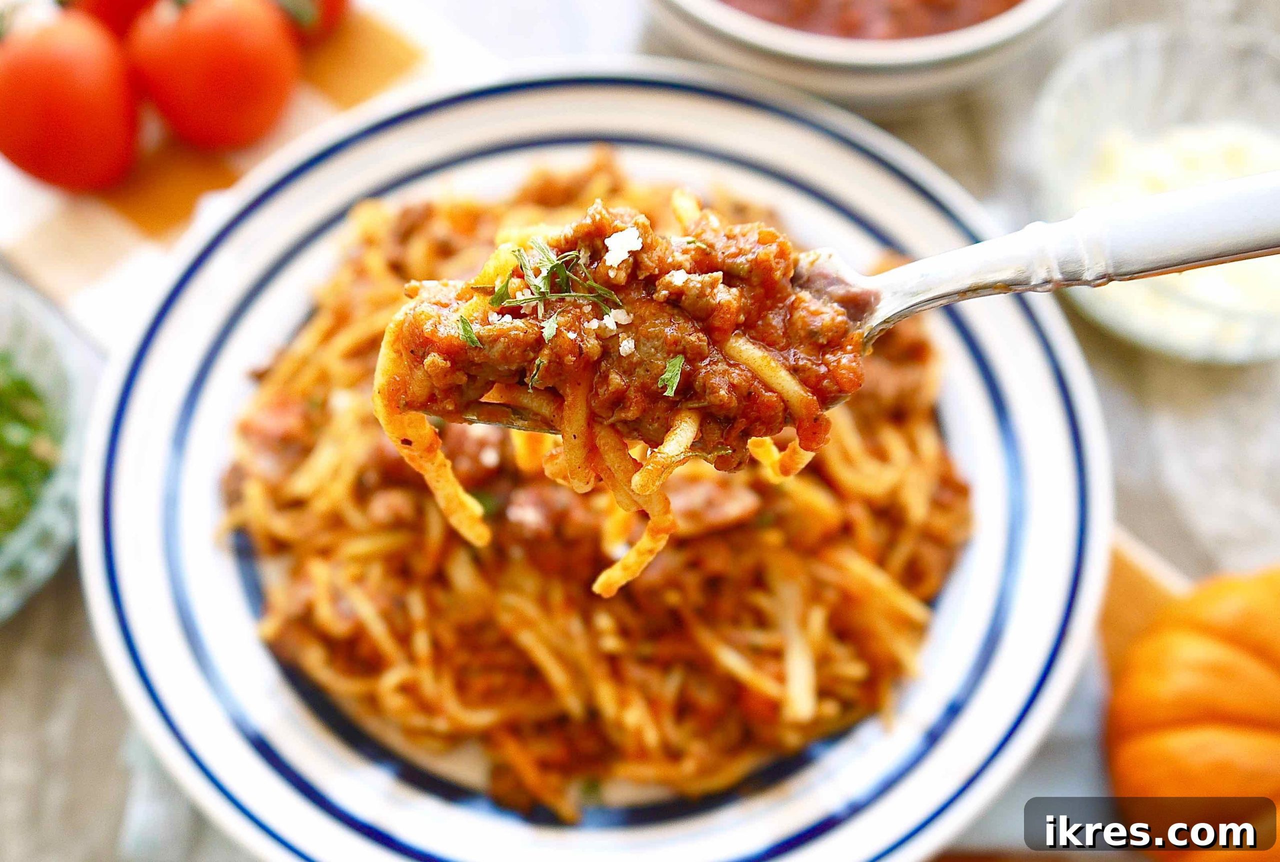 Velvety Pumpkin Ragù 5 A fork holding a bite of rich pumpkin ragu, showcasing the hearty meat sauce and its luscious texture, ready to be enjoyed.