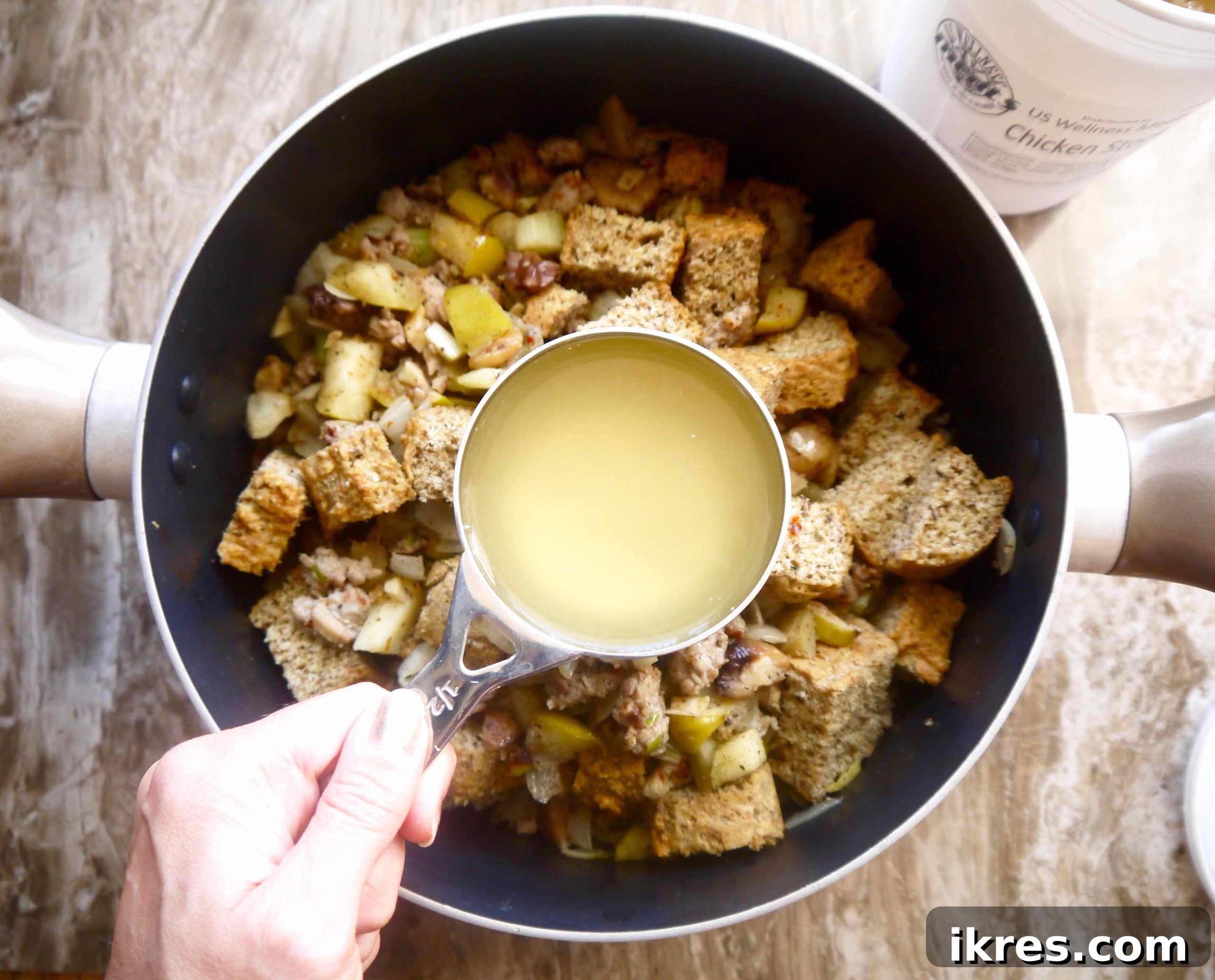 Wholesome Paleo Stuffing with Sausage, Apple and Chestnut Medley 9 Paleo stuffing being mixed in a large pan before baking.
