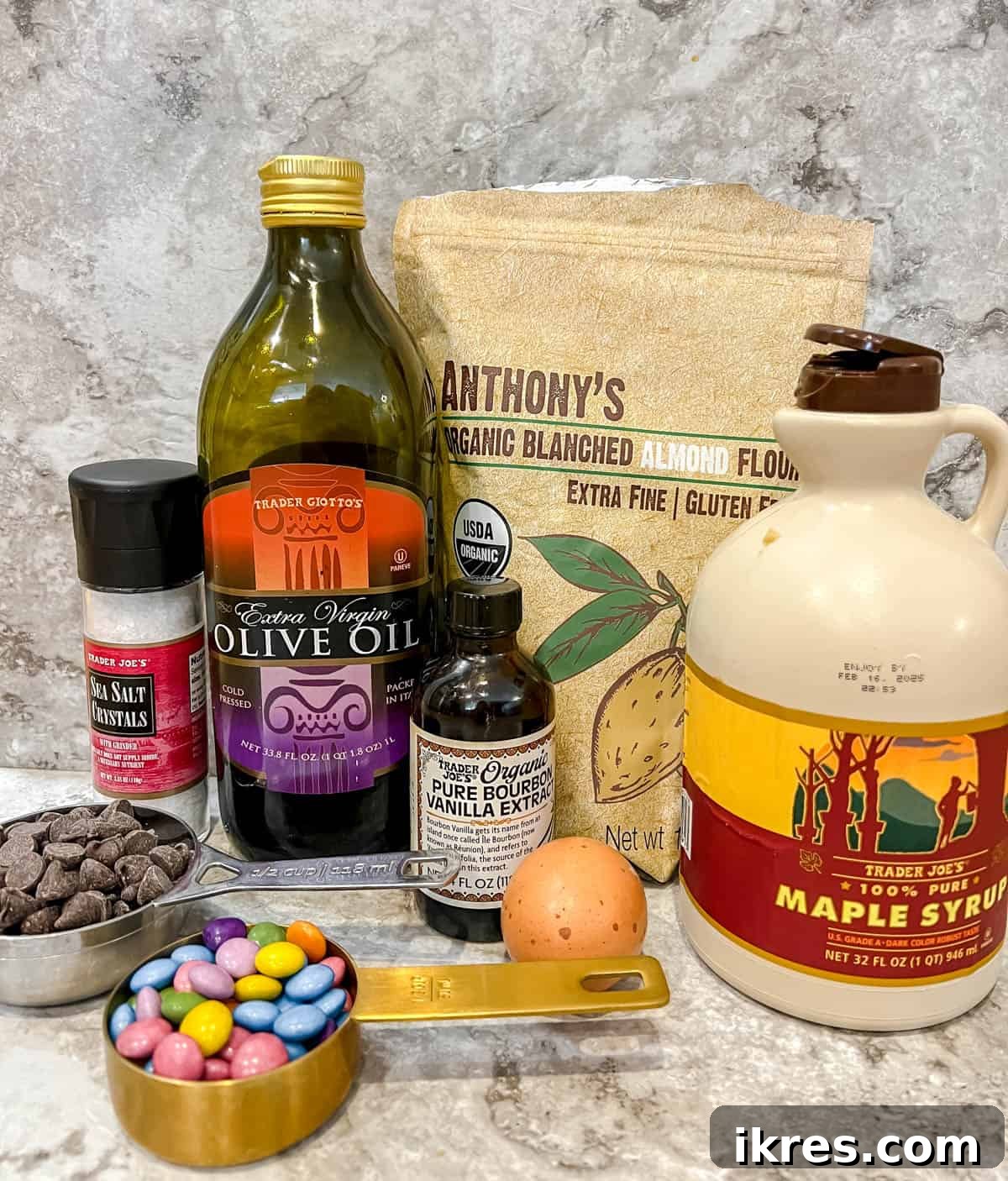 Small Batch Fudgy Almond Flour Brownies (Grain-Free) 3 Collection of fresh ingredients for small batch almond flour brownies: almond flour, olive oil, chocolate chips, egg, maple syrup, vanilla extract, and optional chocolate candies.