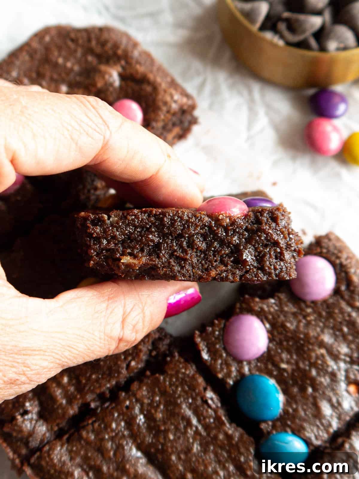 Small Batch Fudgy Almond Flour Brownies (Grain-Free) 9 A hand holding a fudgy slice of gluten-free almond flour brownie, highlighting its rich, moist texture.