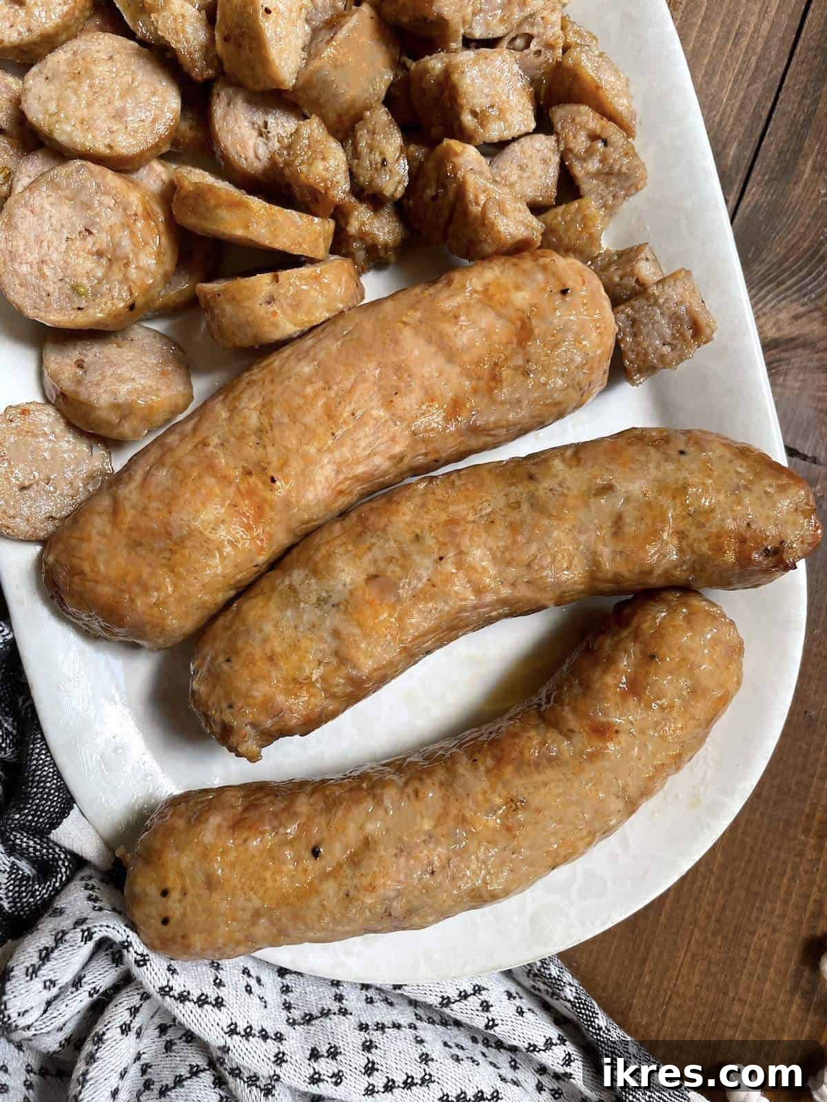 Air Fryer Italian Sausage Perfection 9 Air fried Italian sausages cut in different ways on a white plate.