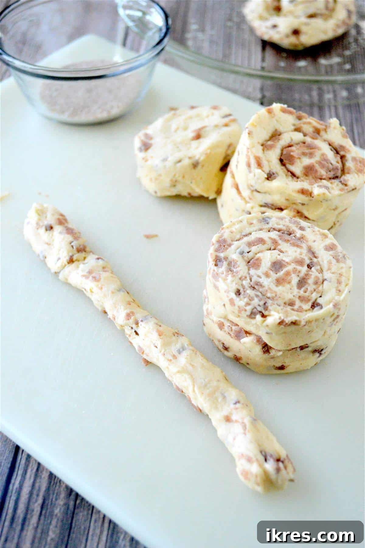 A pile of unrolled cinnamon roll dough sections, showing how to prepare them for forming the giant bun.
