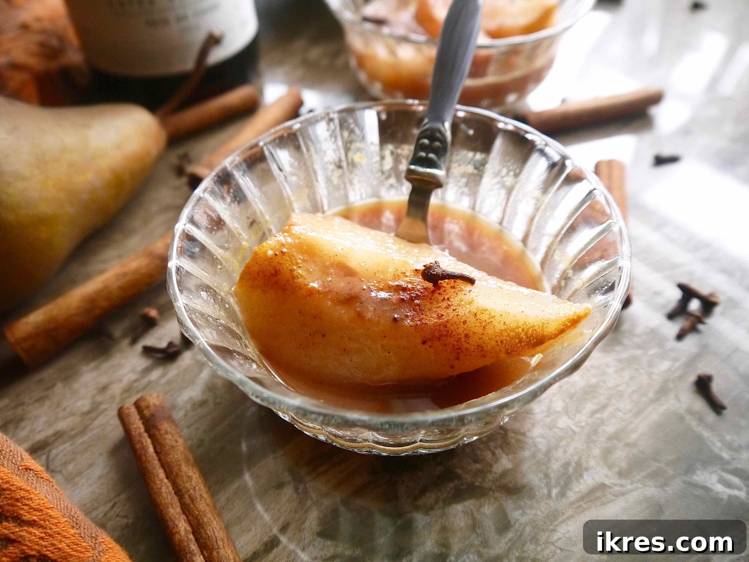 Crimson Pears with Zesty Spice Infusion 3 Two beautifully presented poached pears in orange juice and red wine, ready to be enjoyed.