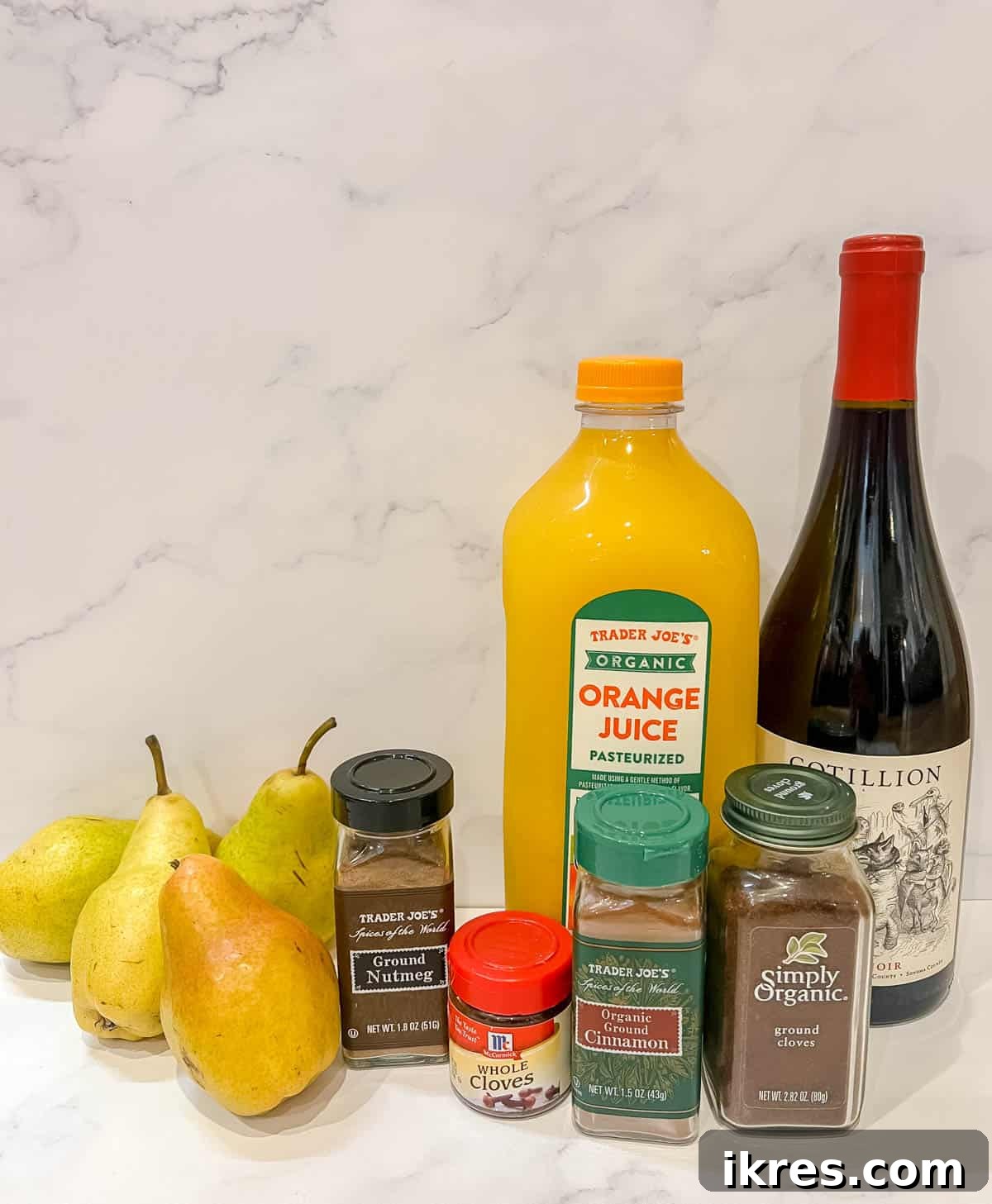Crimson Pears with Zesty Spice Infusion 4 A selection of fresh ingredients including pears, oranges, red wine, and various spices, laid out for making spiced poached pears.