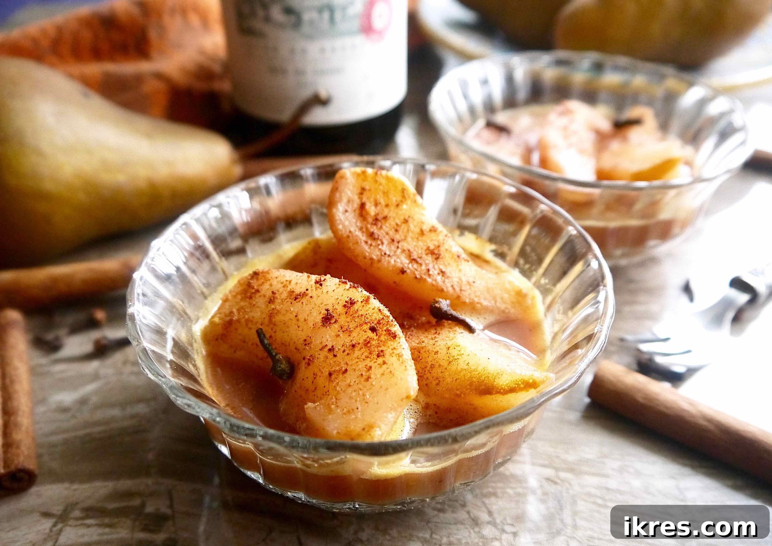Crimson Pears with Zesty Spice Infusion 10 Two bowls of spiced poached pears, garnished with cinnamon sticks, showcasing the vibrant colors and inviting texture of the dessert.