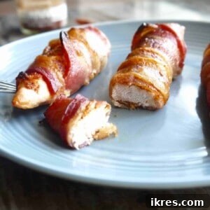 Guilt Free Paleo Keto Bacon Wrapped Chicken Tenders 9 Bacon wrapped chicken tenders on a plate cut into pieces, representing the finished dish.