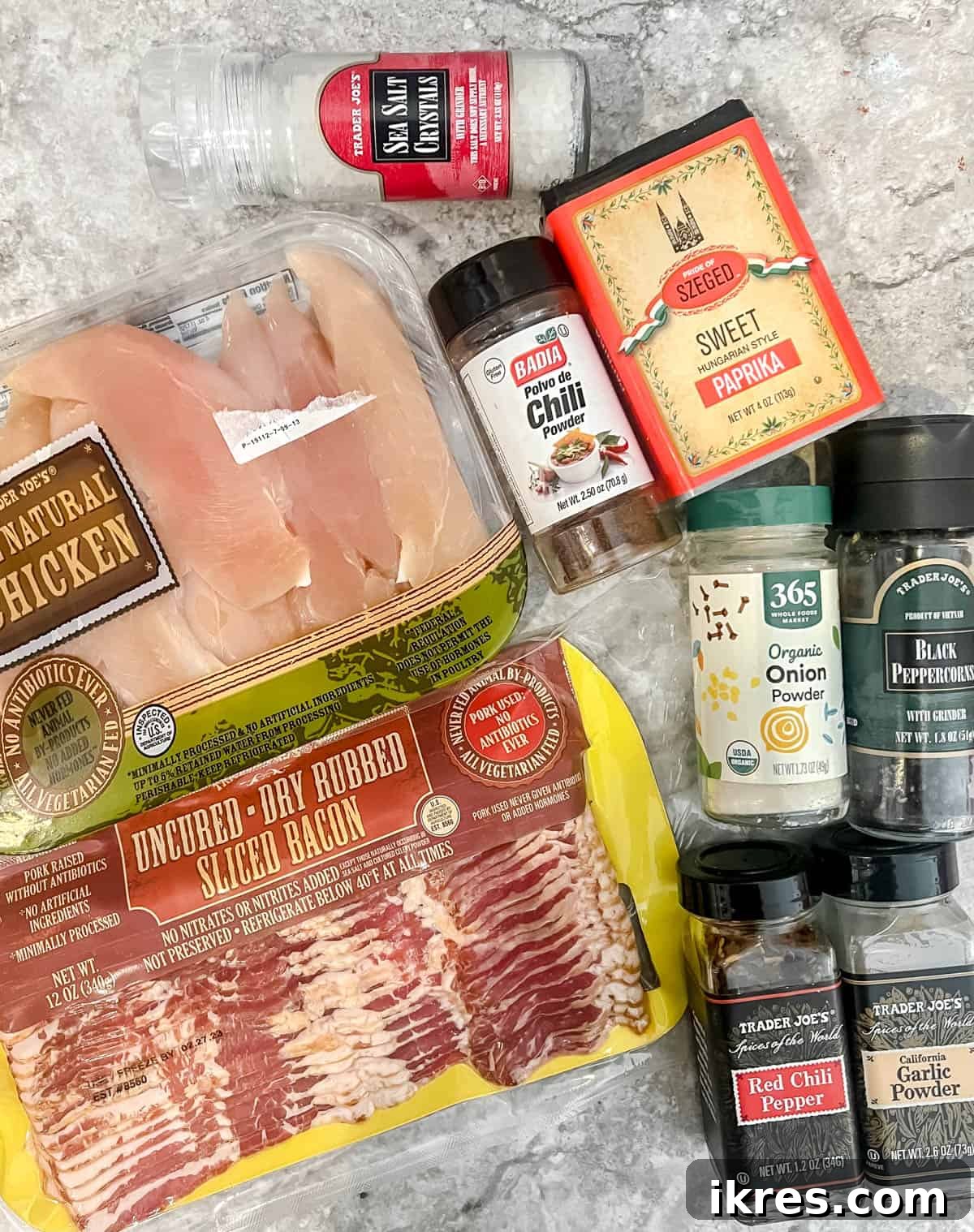 Guilt Free Paleo Keto Bacon Wrapped Chicken Tenders 4 All the fresh ingredients laid out, including chicken tenders, strips of bacon, and various spices.