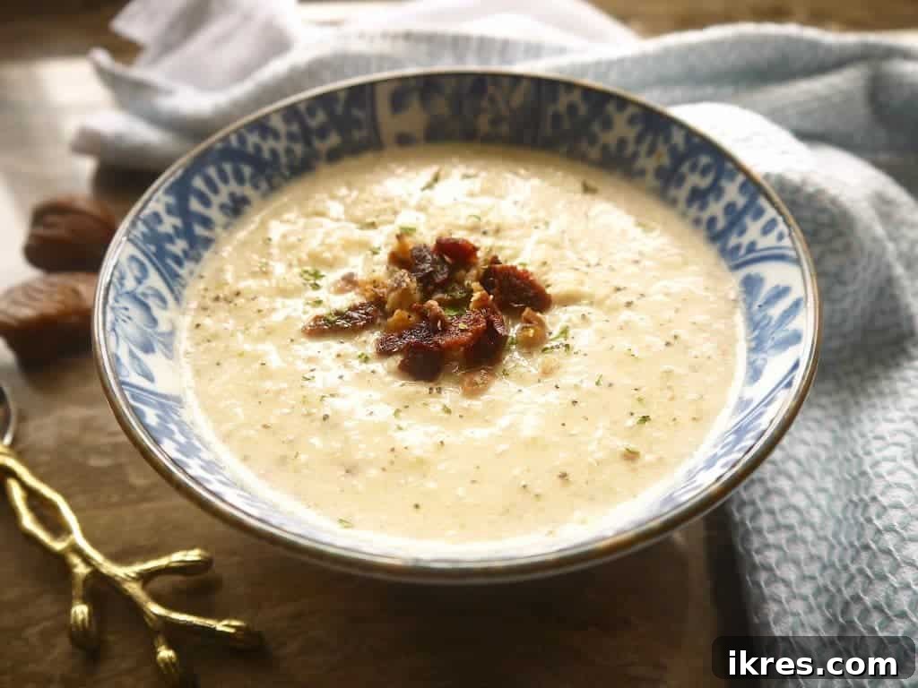 Close-up of the creamy texture of Paleo Cauliflower, Bacon, and Chestnut Soup, showing hints of bacon and chestnuts. Healthy soup recipe.