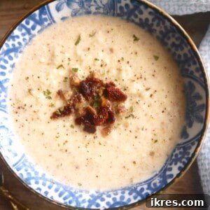 A side shot of a bowl of Paleo Cauliflower, Bacon, and Chestnut Soup, highlighting its creamy texture and rustic appeal.
