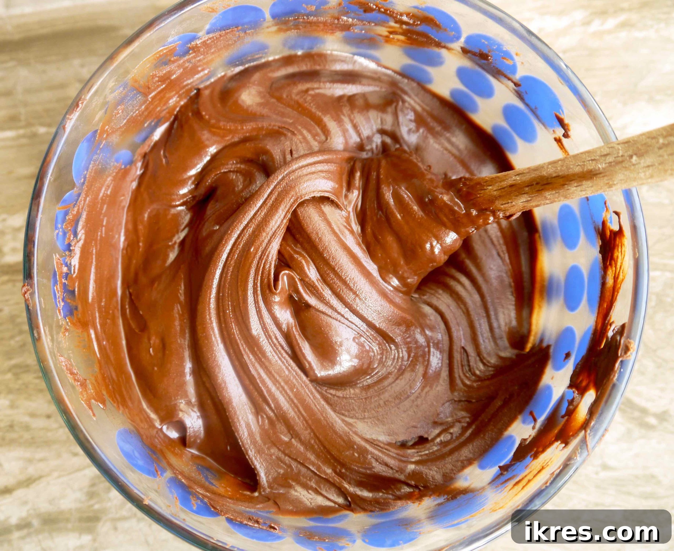 Dairy-free chocolate chips melted into a smooth, glossy liquid in a bowl, ready for mousse preparation.