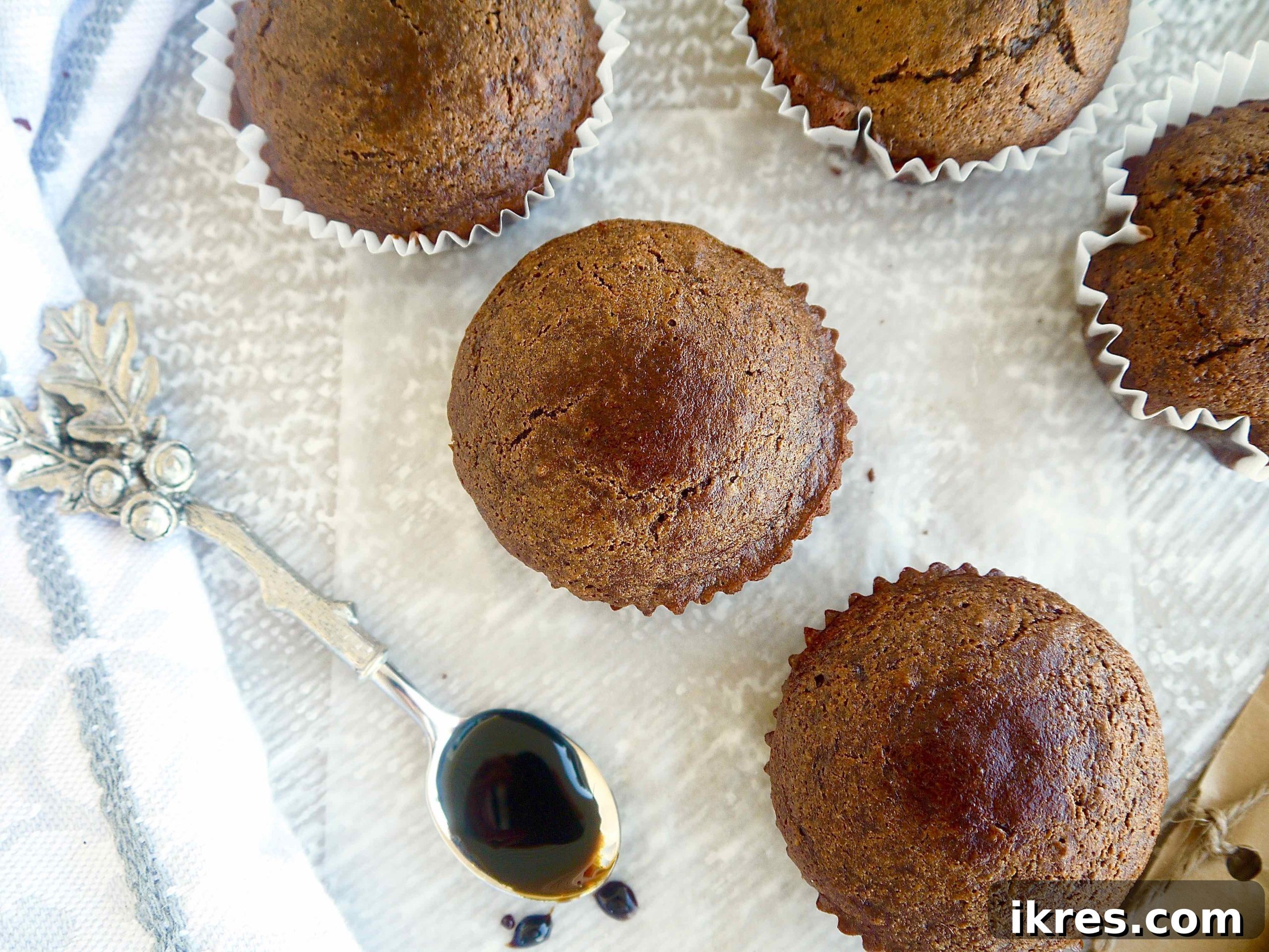 A close-up of a perfectly baked chestnut flour gingerbread muffin, showcasing its golden crumb and the hints of warm spices. A gluten-free and dairy-free delight.