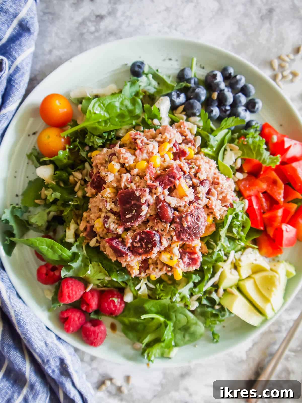 Vibrant Quinoa Beet Salad with Tuna 8 Quinoa Beet Salad served on a white plate, garnished with fresh vegetables and fruit for a complete meal.