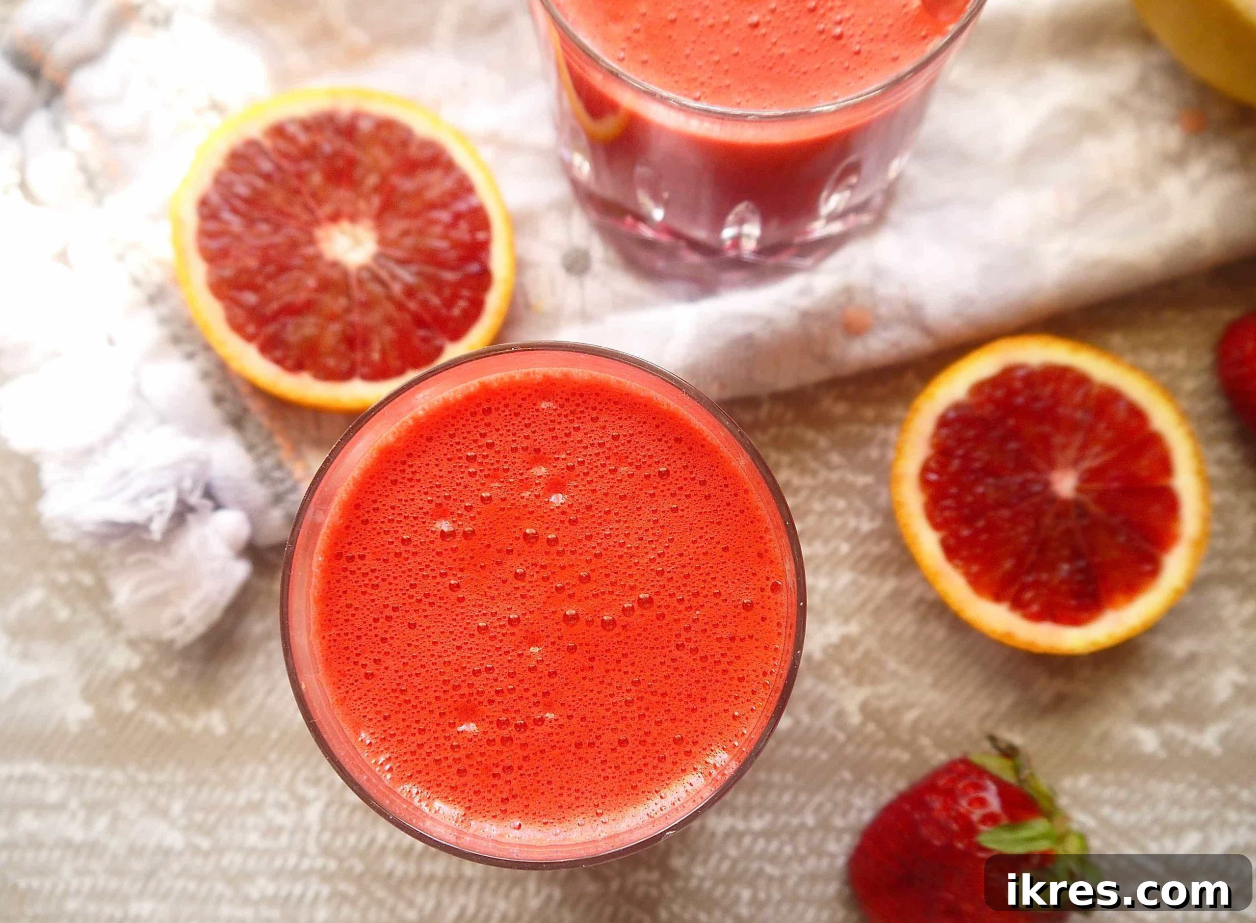 Vibrant Beet and Carrot Juice, ready to drink. Close-up aerial view of a single glass filled with freshly pressed beet and carrot juice, showing its rich, earthy red color.