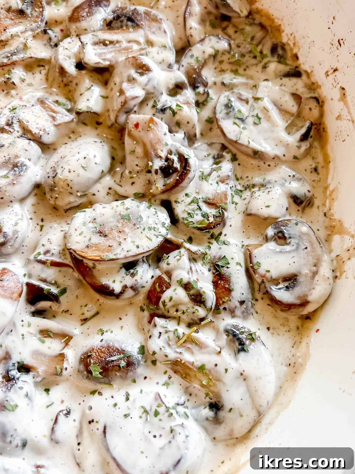 A vibrant, golden-brown vegan mushroom sauce bubbling gently in a frying pan, ready to be served over your favorite meal.