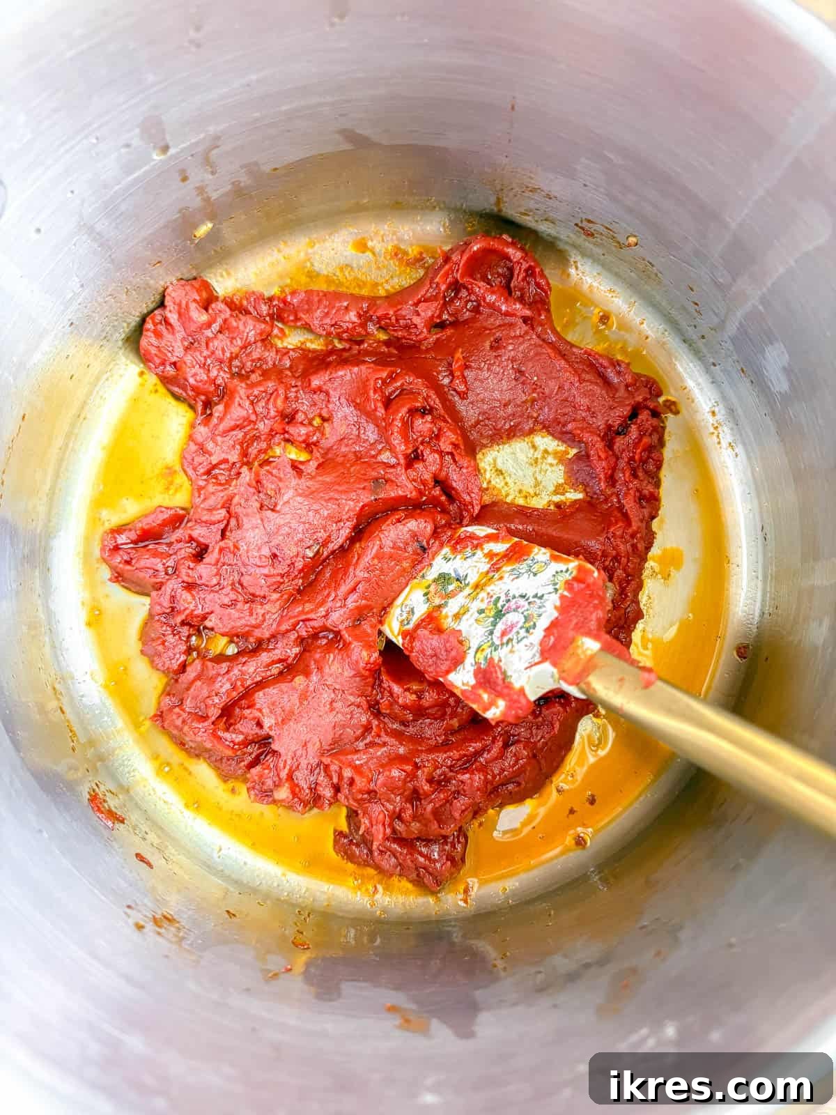 Vegan Vodka Rose Sauce 5 Concentrated tomato paste carefully added to the pan, mingling with the sautéed garlic and chili flakes, ready for caramelization.