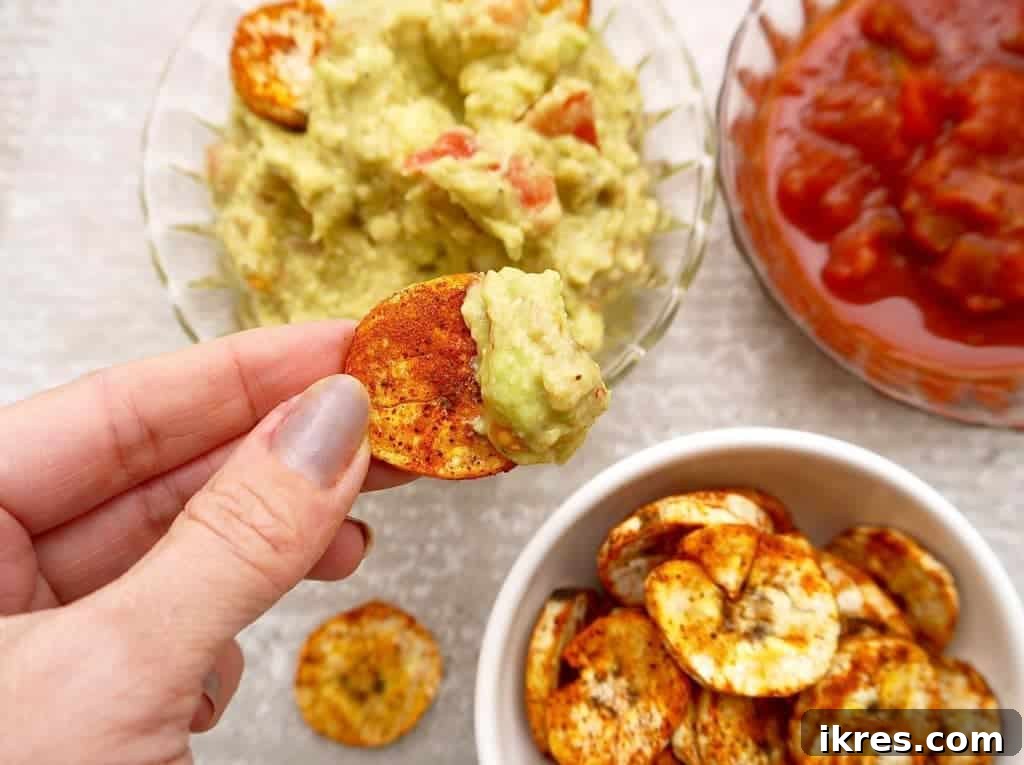 Homemade plantain chips with guacamole and salsa, ideal for dipping.