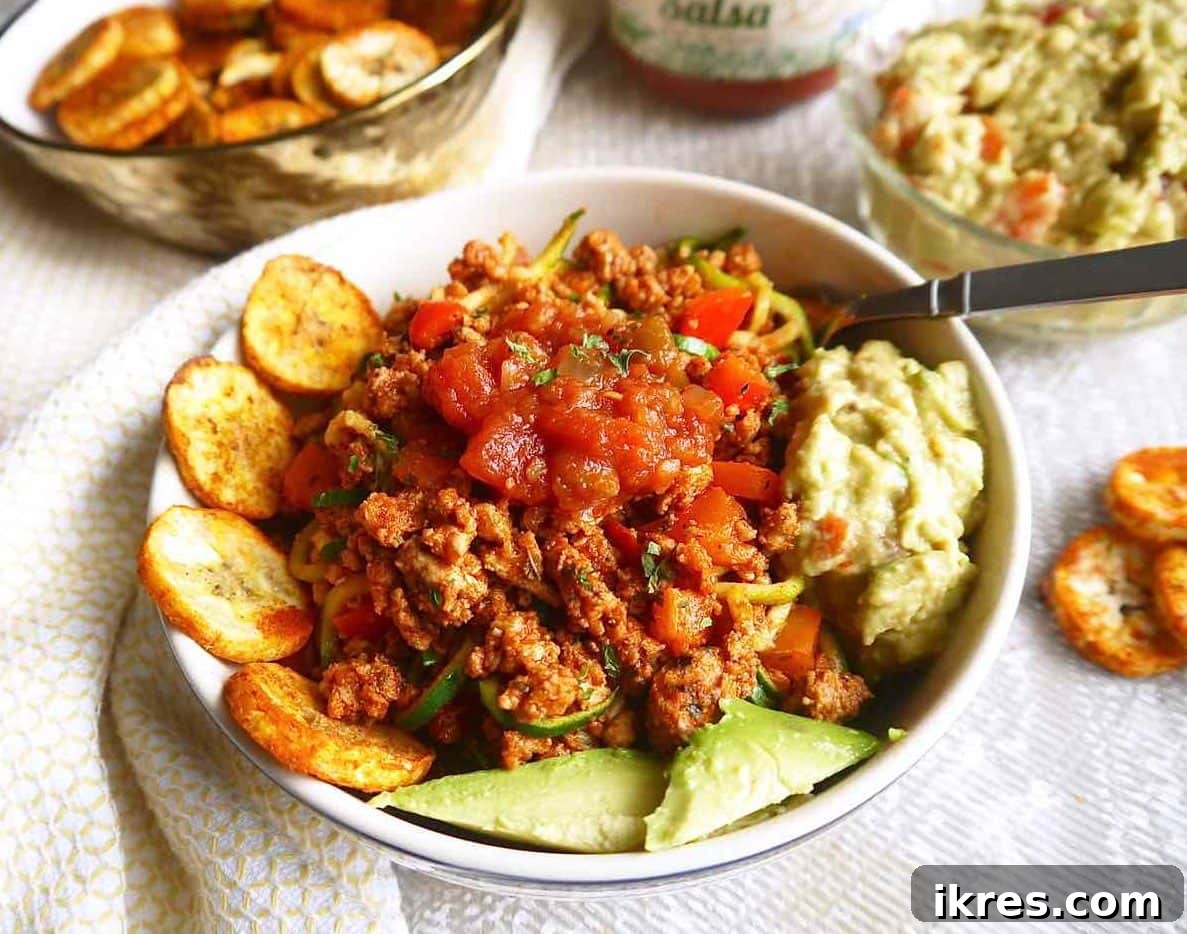 Zesty Turkey Taco Zoodle Bowls 3 A colorful taco bowl featuring ground turkey, vibrant zucchini noodles, and an assortment of fresh taco-inspired toppings.