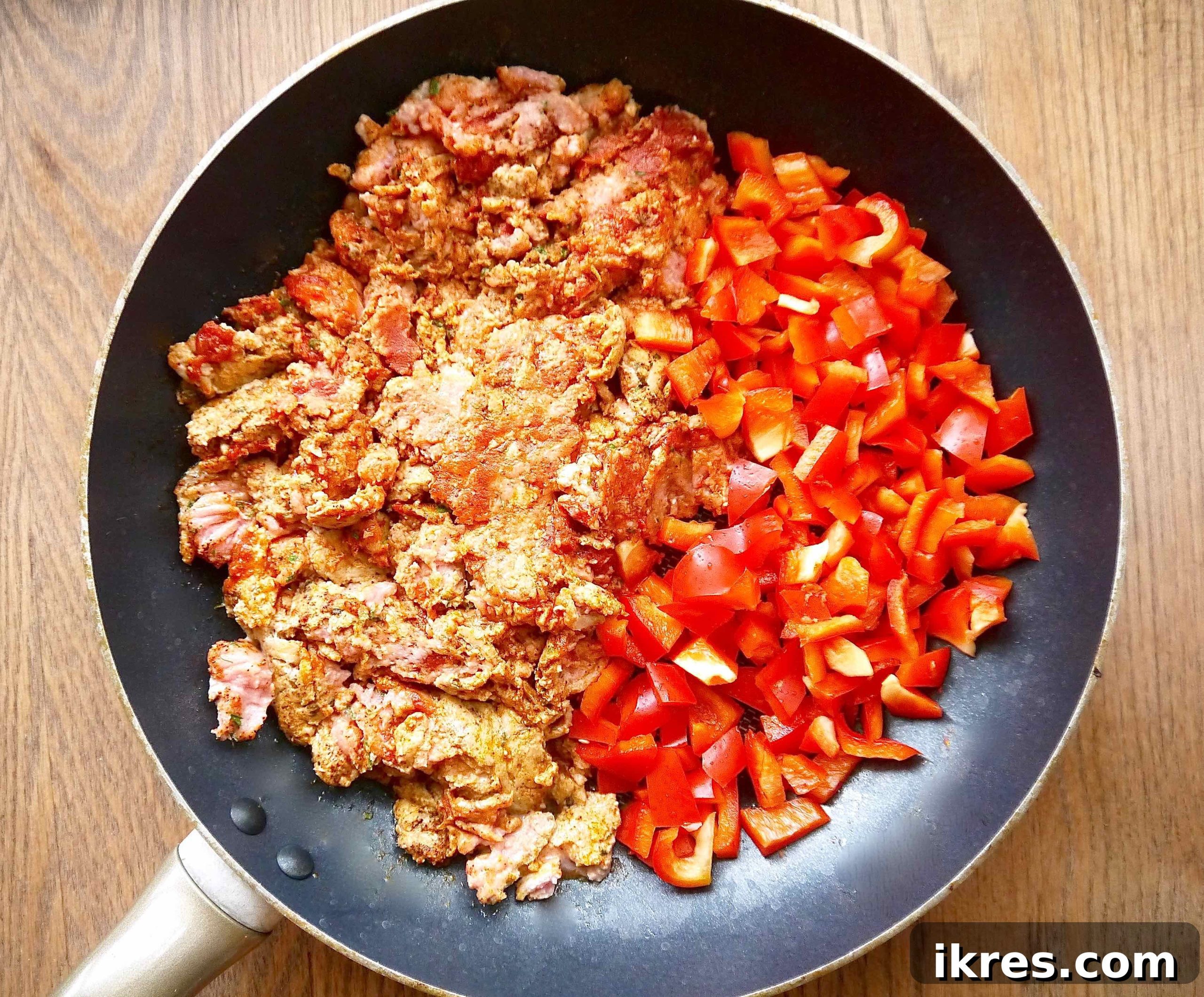 Zesty Turkey Taco Zoodle Bowls 4 Raw ground turkey and diced red bell peppers in a frying pan, ready to be seasoned and cooked.